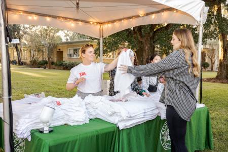 a group of people picking up swags at a swag table